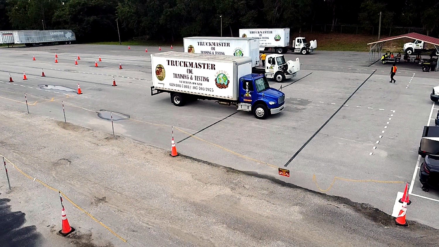 Aerial view of the TruckMaster CDL training yard with branded trucks and cone course in Apopka, FL